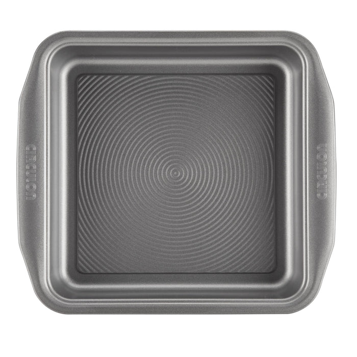 A square baking pan from the 10-Piece Nonstick Bakeware Set, featuring two handles and a textured interior, crafted from heavy gauge steel to resist warping.