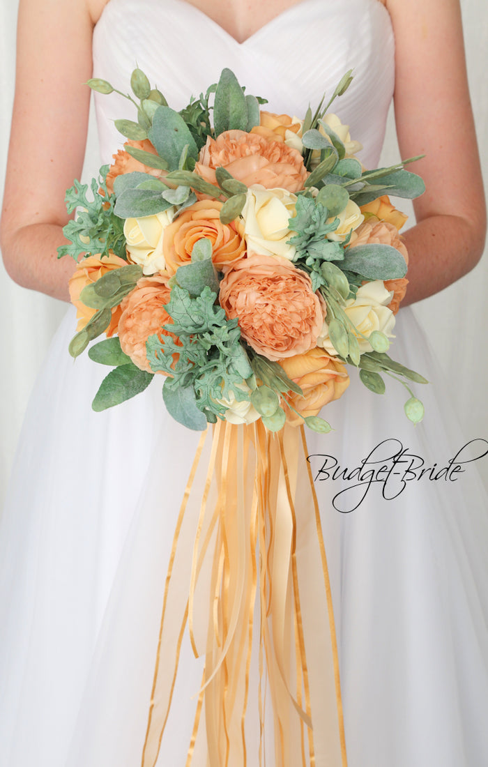 Wedding bouquet with apricot and cream roses and peonies with sage greenery