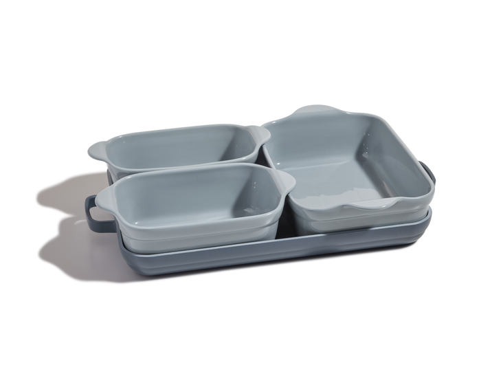 The Bakeware Set includes four light blue ceramic bakers—three rectangular and one square—that nest together neatly on a white background.