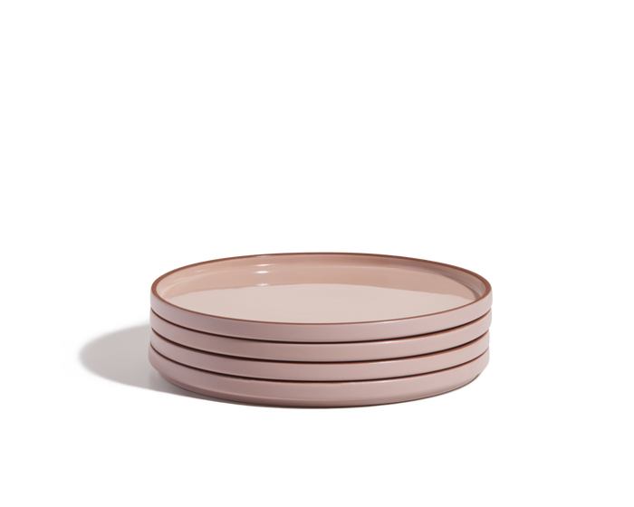 A stack of four round, hand-glazed pink Dinner Plates on a white background, perfect for adding a pop of color to your tableware collection.