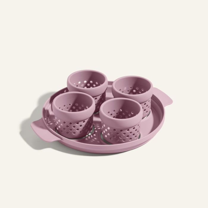 A plastic Egg Poacher set with four purple perforated cups and a matching round tray with handles.