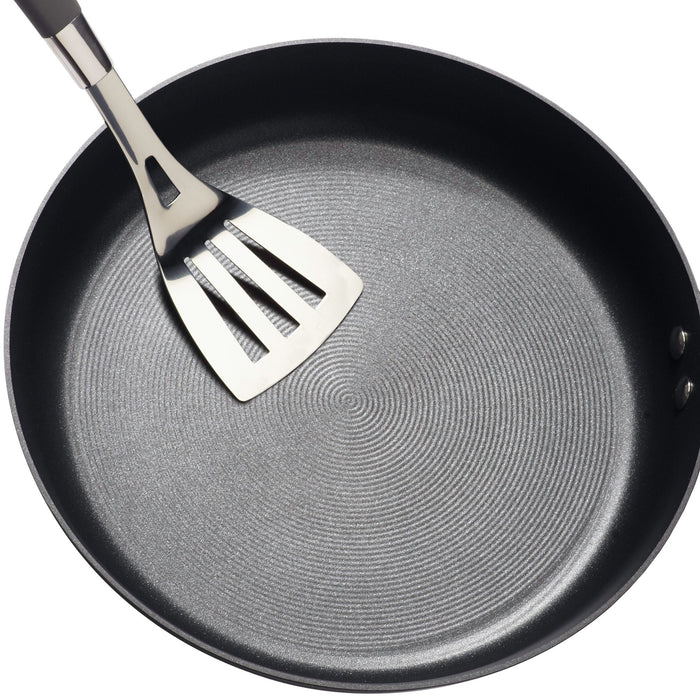 Hard-Anodized Frying Pan Set accompanied by a metal spatula on a white background, showcasing an advanced nonstick system for effortless cooking and cleanup.