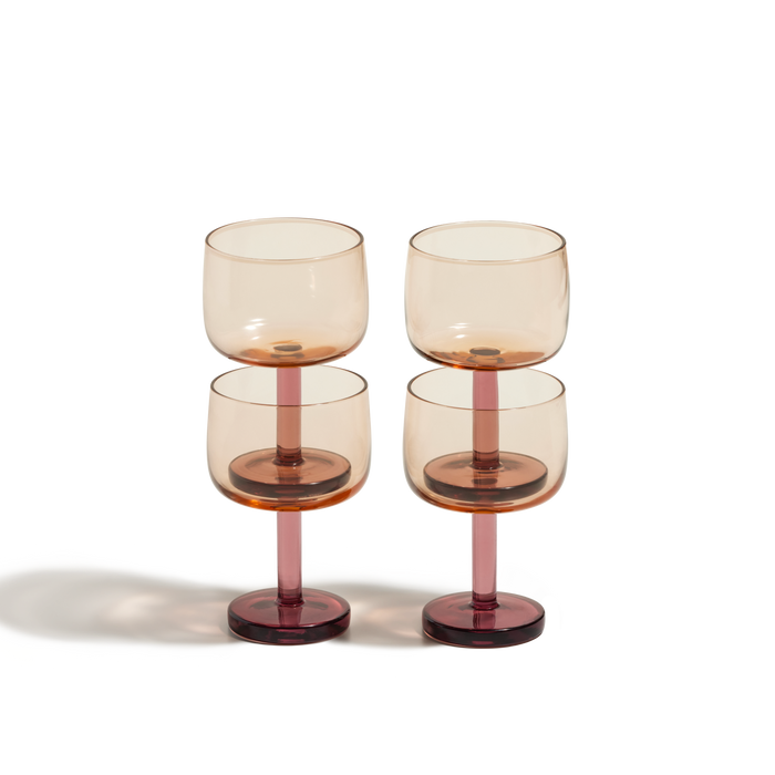 The Party Coupes feature amber-tinted bowls and pink stems in a set of four, arranged in two rows against a white background for a playful addition to your party drinkware.