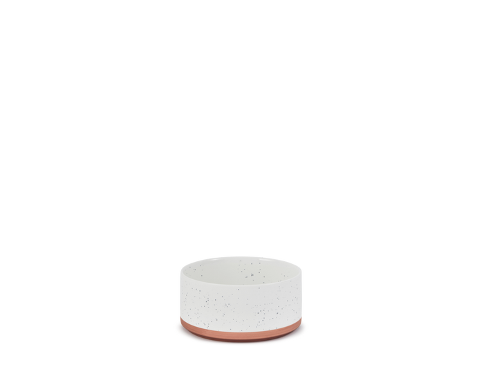 A small, white Side Bowl with subtle speckles and a terracotta-colored base is centered on a plain white background.