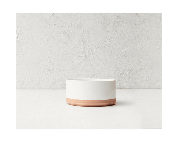 The Side Bowls are small, cylindrical ceramic planters featuring a white upper half and natural terracotta base, inspired by porcelain stackable bowls, and shown against a textured light gray background.