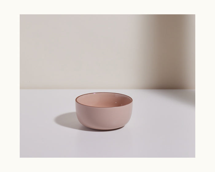 A light pink ceramic Soup Bowl from a stackable set sits on a white surface against a neutral beige background.